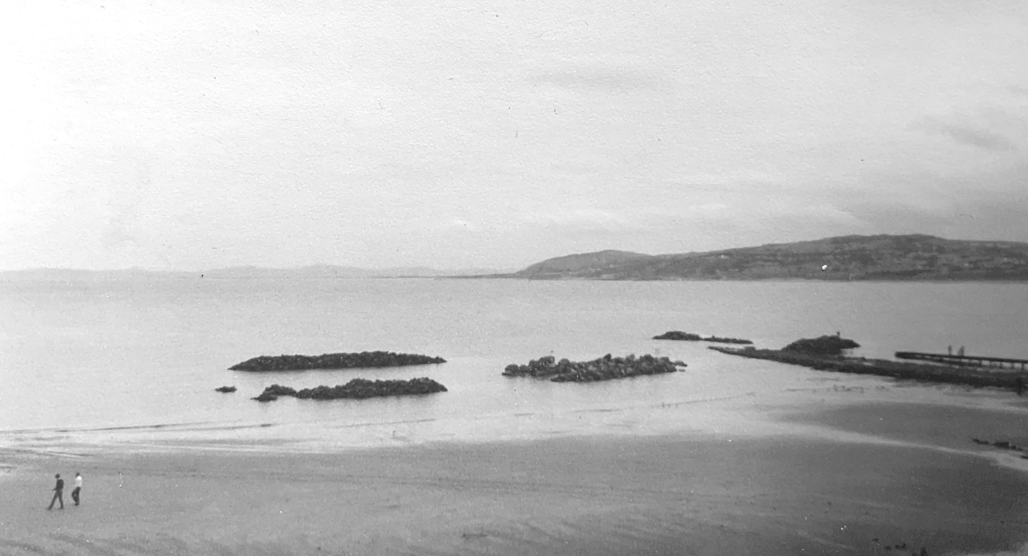 pies of rocks on a beach is the tide comes in around them.